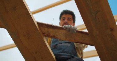 El testeresi ile çalışan yakışıklı adam, Bina Binası, Yavaş çekim marangozu atölyede testereyle tahta kesiyor. Genç inşaatçı testere tahtası Genç inşaatçı testere tahtası