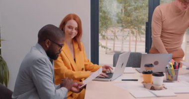 Afrika kökenli Amerikalı erkek ve kızıl saçlı kadın tecrübelerini paylaşıyor, meslektaşları Yavaş çekim panoram görüşü sırasında planlar yapıyor