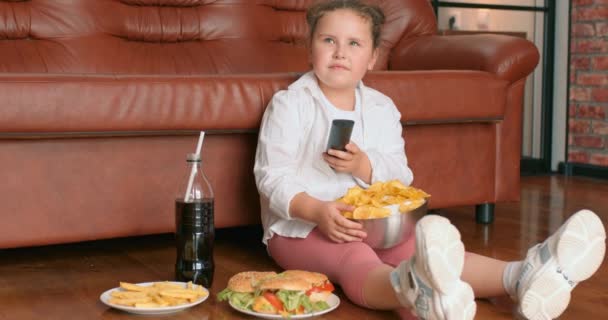 Buttet Overvægtige Søde Pige Spiser Chips Fra Skål Mens Sidder – Stock-video
