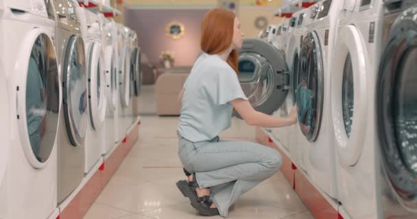 Rödhårig Flicka Öppnar Dörren Odf Tvättmaskin Testa Kontrollera Det Butiken — Stockvideo