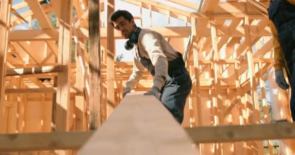 Dwóch Pracowników Niosących Deskę Drewnianą Placu Budowy Poprawa Domu Działa — Wideo stockowe