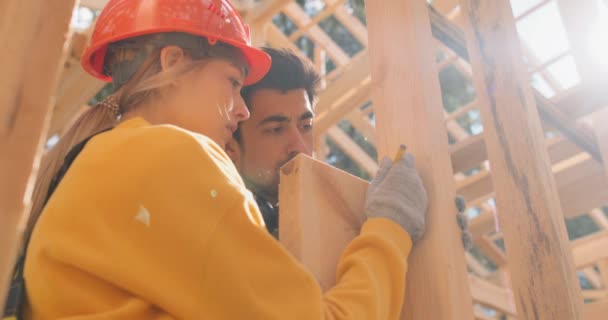 板の大きさを測定する若い男と女スローモーションカップルの建物の家スローモーション — ストック動画