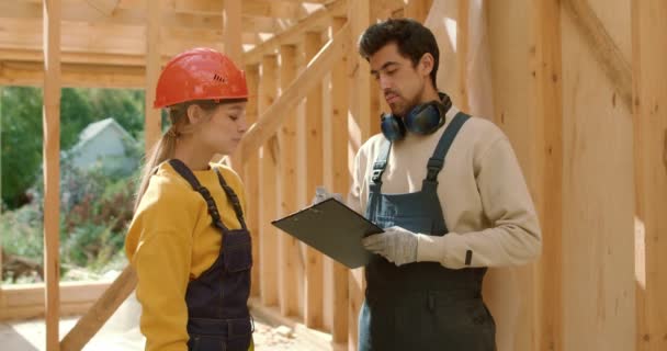 Two Builders Designers Woman Man Inspecting Work Builder Construction Wooden — Stock Video