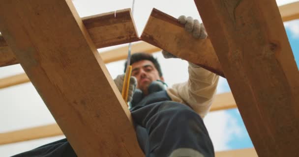 Schöner Mann Steht Auf Holzkonstruktion Hausrahmen Zeitlupe Bauarbeiter Sägt Holz — Stockvideo
