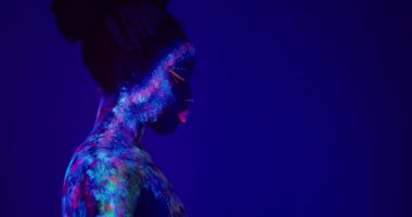Güzel, sakin, dünya dışı model bir kadının yan görüntüsü. Pembe dudaklı, neon ışıklı, fotoğraf makinesine bakıyor. Sanat tasarımı fotokopi alanı, bireysellik arzusu ve sosyal ortamlarda göze çarpıyor..