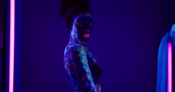 迪斯科性感女孩与辉光化妆站在工作室与荧光灯身体的绘画 身体艺术 慢动作 — 图库视频影像