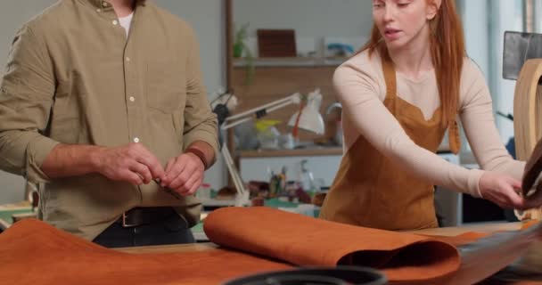 本物の革 縫製手作りのアクセサリー クラフトワークショップのバッグで働く若い男女 ビジネス — ストック動画