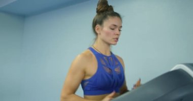 Motive olmuş genç kız spor salonunda tek başına koşuyor, antrenman yapıyor, yavaş çekim, yan görüş, kaslı bacaklara odaklanıyor, sporcu kadın kalori yakıyor. Kilo Kaybı