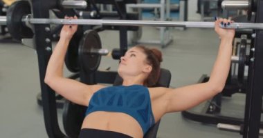 Sportif kadın spor salonunda halterle egzersiz yapıyor. Ağır çekimde sağlık ve vücut bakımı, yaşam tarzı sağlık Boş zaman, hobi, ilgi alanları