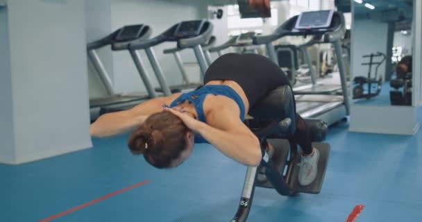 运动健康的女人锻炼腹部肌肉 健身野心勃勃的女孩子在长椅上锻炼 慢动作 女孩子过着健康的生活 — 图库视频影像