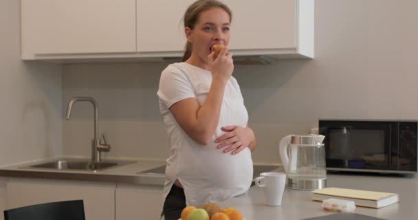 Вагітна Жінка Стоїть Кухні Їсть Яблуко Яблуко День Тримає Лікаря — стокове відео