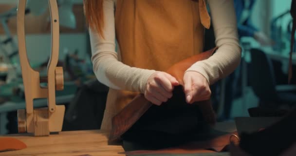 Kvinna Förkläde Kontrollera Kvaliteten Och Strukturen Läder Pjäs Slow Motion — Stockvideo