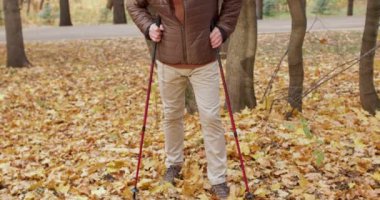 Aktif hırslı emekli adam, İskandinav bastonlarıyla yürümekten zevk alıyor. Ormanda, parkta durup, dışarıda yavaş çekim eğlence aktiviteleri yapmaktan. Sağlık ve Vücut Sağlığı