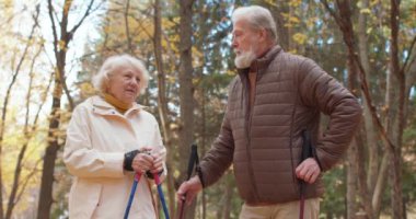 Sonbahar günü doğa yürüyüşünde motive olmuş son sınıf öğrencileri. Ağır çekimde yaşlı insanlar sağlıklarına dikkat ederler.