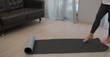 Hamile bir kadın yoga minderini yere seriyor nefes almak için egzersiz yapıyor spor motivasyonu konsepti yapıyor yavaş çekim kızı oturma odasında yoga yapıyor, sağlık ve vücut bakımı yapıyor.