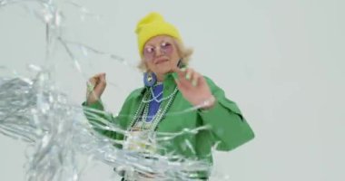 Son sınıf öğrencisi, enerjik, modaya uygun giyinmiş, diskoda dans eden, yavaş çekim mutluluğu, yaşam sevgisi olan, asla pes etmeyen, iyimser yaşlı bir kadın.