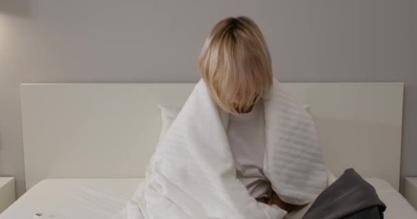 Εξαντλημένη Αναστατωμένη Νεαρή Γυναίκα Που Κάθεται Στο Κρεβάτι Και Υποφέρει — Αρχείο Βίντεο