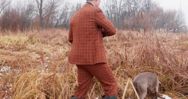 Hunter Com Cão Caça Passa Por Uma Lagoa Outono Campo — Vídeo de Stock