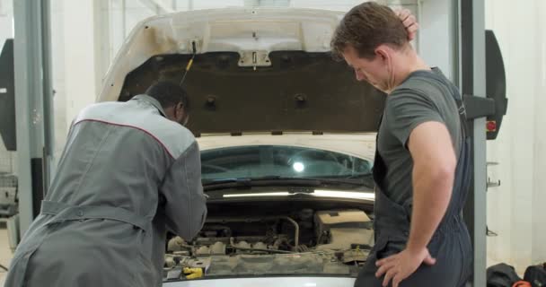 Biali Afroamerykanie Weseli Młodzi Mężczyźni Mechanicy Samochodowi Mundurach Przybijcie Piątkę — Wideo stockowe