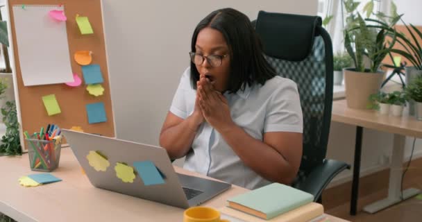 アフリカ系アメリカ人女性が自宅のオフィスでラップトップを使用して怒って怒った コンピュータの問題に混乱した 女の子は手を上げた女性の喜びのファイル 誤ってプロジェクトで肩を振る — ストック動画