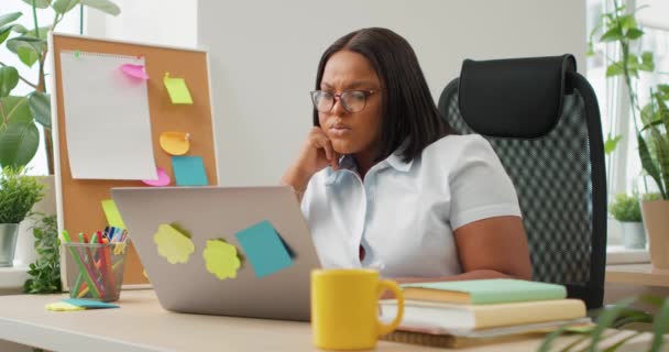 ノートパソコンでネガティブなショックを見ている混乱したアフリカ系アメリカ人女性 悪い結果の失敗ビジネス問題 オンラインホームオフィスのイライラした学生ガールは プロジェクト 試験の結果に満足していません — ストック動画