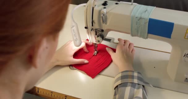 Молодая Рыжая Женщина Учится Пользоваться Швейной Машинкой Редкий Вид Сзади — стоковое видео