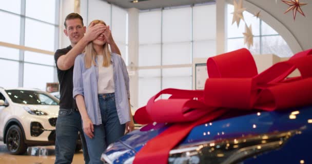 Çift Yeni Mavi Arabanın Önünde Durur Adam Karısının Gözlerini Elleriyle — Stok video
