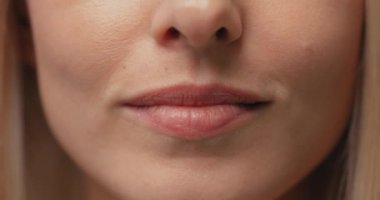 Sarışın, güzel, genç bir kadının yüzünün beyaz ve sağlıklı dişleri var. Gülümseyen güzel kadın dudaklarını kapat Ağır çekim Sağlık Hizmetleri
