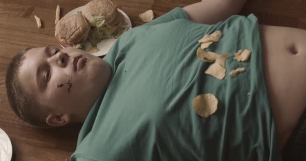 Tired Sleepy Fat Boy Eat Junk Food While Lying Floor — Stock Video