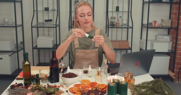 プロの香水業界アナリストによる新しい香水ブログに取り組んでいる少女 ビューティスキンケア パイプで香水を準備する若い女性 ワークショップのテーブルでエッセンシャルオイル パイプからへ — ストック動画