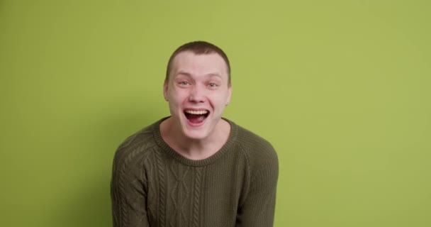 Uśmiechnięty Młody Człowiek Nosi Zielony Sweter Taniec Zaciskając Pięści Machając — Wideo stockowe
