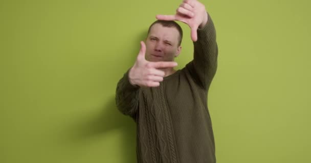 창의력 사진을 배경에 잘생긴 남자는 손가락 프레임 손가락으로 프레임을 만드는 — 비디오
