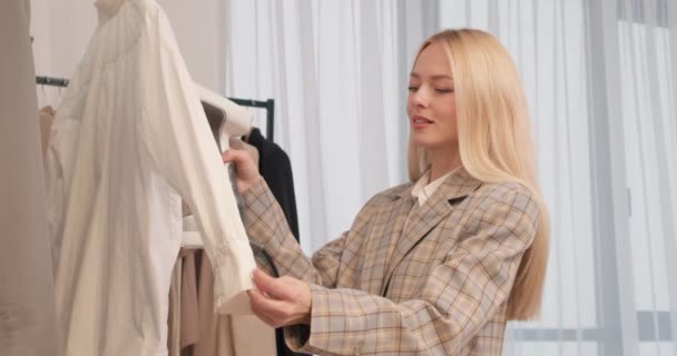 Joven Rubia Mujer Humeante Camiseta Blanca Blusa Tienda Ropa Cámara — Vídeos de Stock