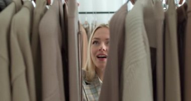 Mutlu, gülümseyen bir kadın elbise asarken alışveriş yaparken ve tüketim konsepti olan bir kadın ne giyeceğine karar verir. Moda tarzı, heyecanlı kız yeni moda moda kıyafetlerden zevk alıyor.