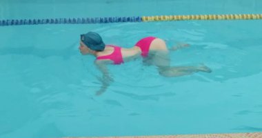 Young sexy woman raising her butt up while swimming slow motion. Beautiful hot lady in bikini. Luxury butt. Sensual seductive young girl in swimming pool.