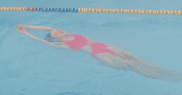 Frau Stylischem Rosa Badeanzug Schwimmt Auf Dem Rücken Pool Mädchen — Stockvideo
