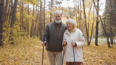Mutlu yaşlı adam ve kadın kameraya bakıyor. Ormanda ağır çekim yaparken. Ailesiyle yakın çekim hafta sonu.