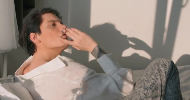紧张的人什么都厌倦了 慢动作 一个情绪化的家伙带着尼古丁贴片和香烟在卧室里 — 图库视频影像