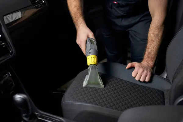 Worker Cleans Car Interior With Vacuum Cleaner Stock Photo