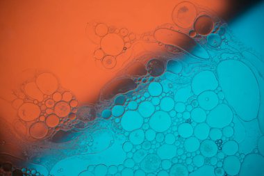 Sıvıdaki yağ kabarcıklarının üst görüntüsü. Yağ yüzeyi çok renkli arka plan. Renkli kabarcıklardan oluşan fantastik bir yapı. Suda yüzen yağ damlasının renkli sanatsal görüntüsü