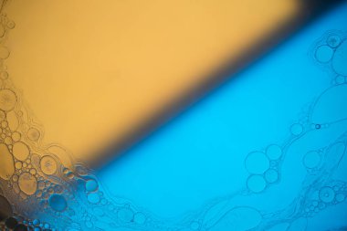 Sıvıdaki yağ kabarcıklarının üst görüntüsü. Yağ yüzeyi çok renkli arka plan. Renkli kabarcıklardan oluşan fantastik bir yapı. Suda yüzen yağ damlasının renkli sanatsal görüntüsü