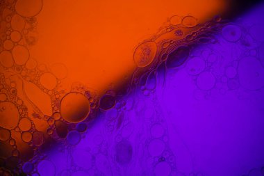 Sıvıdaki yağ kabarcıklarının üst görüntüsü. Yağ yüzeyi çok renkli arka plan. Renkli kabarcıklardan oluşan fantastik bir yapı. Suda yüzen yağ damlasının renkli sanatsal görüntüsü