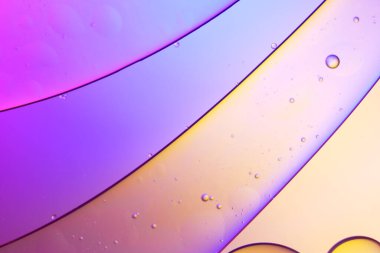 Sıvıdaki yağ kabarcıklarının üst görüntüsü. Yağ yüzeyi çok renkli arka plan. Renkli kabarcıklardan oluşan fantastik bir yapı. Suda yüzen yağ damlasının renkli sanatsal görüntüsü