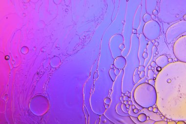 Sıvıdaki yağ kabarcıklarının üst görüntüsü. Yağ yüzeyi çok renkli arka plan. Renkli kabarcıklardan oluşan fantastik bir yapı. Suda yüzen yağ damlasının renkli sanatsal görüntüsü