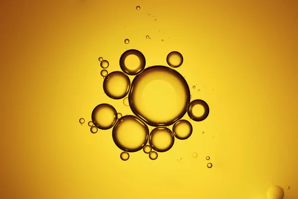Top view movement of oil bubbles in the liquid. Oil surface multicolored background. Fantastic structure of colorful bubbles. Colorful artistic image of oil drop floating on the water