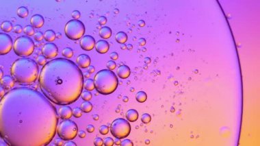 Sıvıdaki yağ kabarcıklarının üst görüntüsü. Yağ yüzeyi çok renkli arka plan. Renkli kabarcıklardan oluşan fantastik bir yapı. Suda yüzen yağ damlasının renkli sanatsal görüntüsü