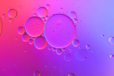 Sıvıdaki yağ kabarcıklarının üst görüntüsü. Yağ yüzeyi çok renkli arka plan. Renkli kabarcıklardan oluşan fantastik bir yapı. Suda yüzen yağ damlasının renkli sanatsal görüntüsü