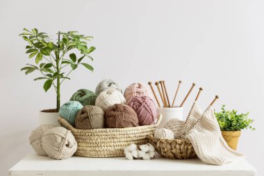 Hasır sepetin içindeki çeşitli pastel renkli toplarda doğal yün..