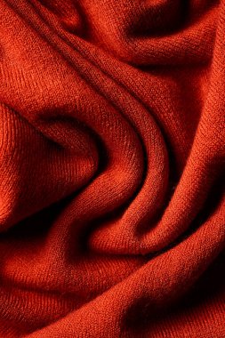 Yumuşak kıvrımlı kırmızı yün kumaş ve detaylı tekstil yapısı. Sıcak tekstil arkaplanı