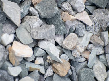 Ayrıntılı mineral dokuları olan engebeli taş bir yüzeye yakın çekim, doğal jeolojik oluşumlar gösteriyor..